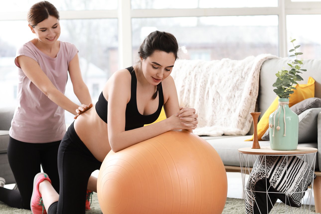 Doula Massaging Pregnant Woman at Home